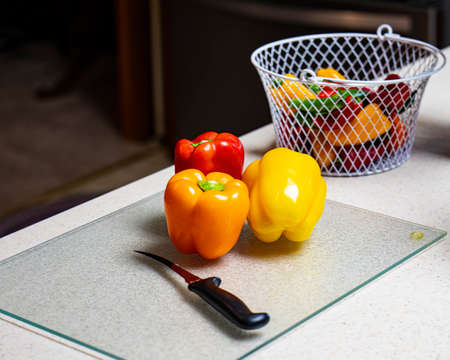 Fresh, colorful peppers sitting on a countertop.