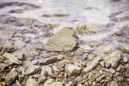 Stones and water surface in the riversideの写真素材