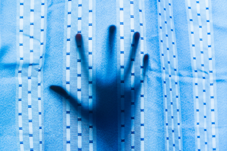 Creepy hand behind curtain, happy halloween, with soft focus and blur.