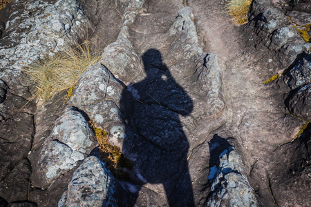 Man's shadow on the rock and stone yard  in strange shape.の写真素材