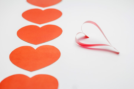 Paper and ribbon shaped as hearts on white background, valentine day.の写真素材