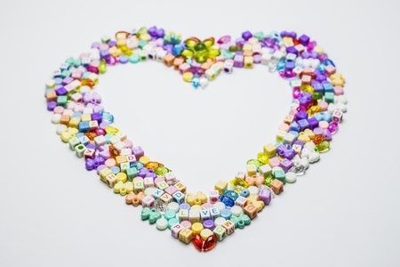 Colorful of beads with heart shape on white background.の写真素材