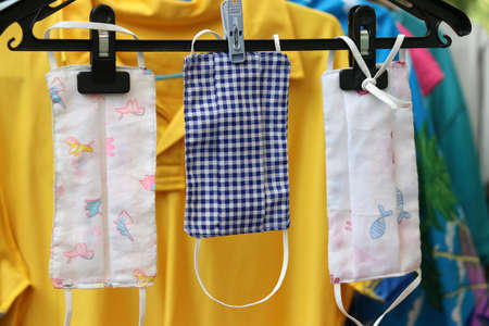 DIY handmade protective fabric masks in Thailand hanging on the clothes line.の写真素材