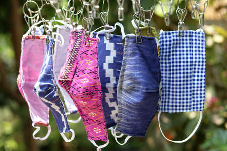 DIY handmade protective fabric masks in Thailand hanging on the clothes line.  Thai people make own...