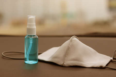 Reusable cloth mask and alcohol based hand sanitizer spray placed on car console.Concept about new normal,social distancing,business,   and travel guideline for prevention of Covid-19 (Coronavirus).の写真素材