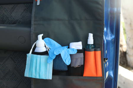 Lifestyle and travel concept in the New Normal after Covid-19 / Coronavirus pandemic. Hanging bag in car consisting of liquid soap ,medical mask,hand towel,disposable gloves and hand sanitizer spray.の写真素材
