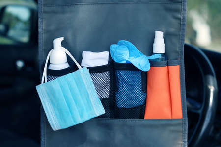 Lifestyle and travel concept in the New Normal after Covid-19 / Coronavirus pandemic. Hanging bag in car consisting of liquid soap ,medical mask,hand towel,disposable gloves and hand sanitizer spray.の写真素材