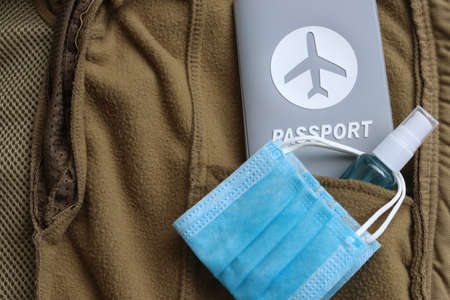Passport travel,hand sanitizer spray and medical mask in jacket pocket with copy space. Tourism, holiday and traveling concept in New Normal after   pandemic.の写真素材