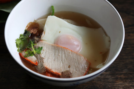 Thai noodles style, traditional steamed rice noodle in pork soup with egg and vegetable,garnished with fresh cilantro.の写真素材