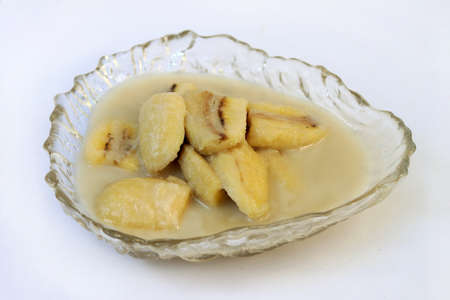 Homemade cultivated banana in coconut milk recipe on white background. One of popular traditional dessert of Thailand and Southeast Asia.の写真素材