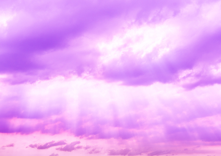 Purple fantasy sky with clouds and light shining throughの写真素材
