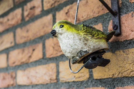 Fake Robin bird garden decoration sculpture on the brick wallの写真素材