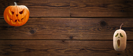 carved halloween pumpkins on wooden planks backgroundの写真素材