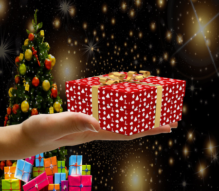 Christmas concept a hand holding a decorated wrapped christmas present box isolated on a christmas...