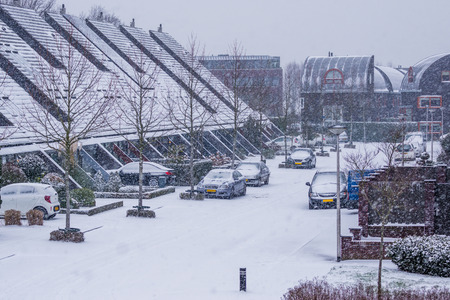 streets of a village during a cold winters day in a snow storm, modern dutch neighborhood in winter seasonの写真素材