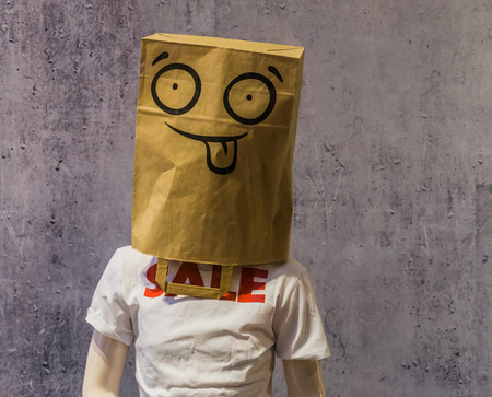 dummy wearing a funny paper bag on its head and a t-shirt with Sale on it, shopping discount conceptの写真素材