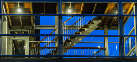Stairs in a modern staircase building with glass windows, lighted at night, dutch architectureの写真素材