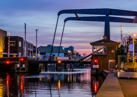 the popular city bridge alphensebrug in Alphen aan den Rijn, the Netherlands, beautiful water scenery at sunsetの写真素材