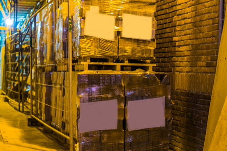 big row of stacked pallets full of stone tiling, pallets with blank labels, logistics and construction industry backgroundの写真素材