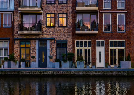 beautiful modern dutch city architecture at night, terraced houses at the canal with balconies, Alphen aan den Rijn, The Netherlandsの写真素材