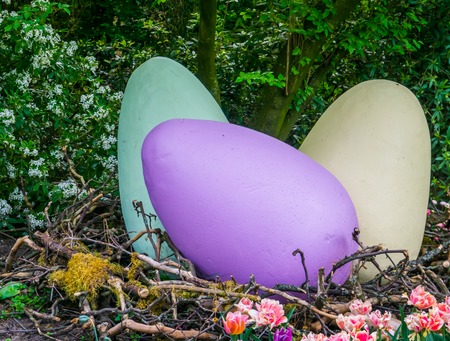 large vivid colored easter eggs in a big birds nest, outdoor holiday decorations, spring season backgroundの写真素材