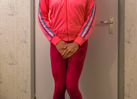 young Women wetting her leggings and holding her hands in front of her crotch, Embarrassing...