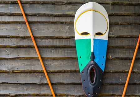 traditional african wooden mask hanging on a wooden wall, African culture backgroundの写真素材