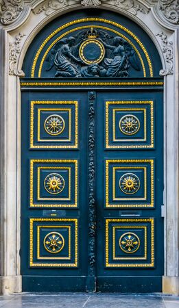 Old classic doorway decorated with gold and patterns, angel statues above the door, historical architectureの写真素材