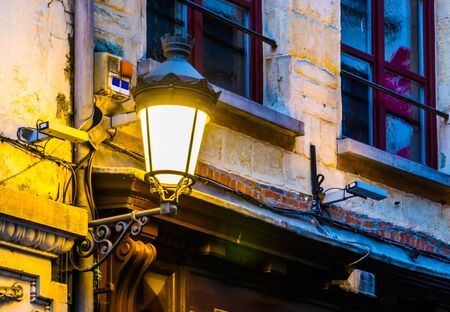 lighted vintage street lantern on the wall of a city house, Flemish architecture, outdoor lightingの写真素材