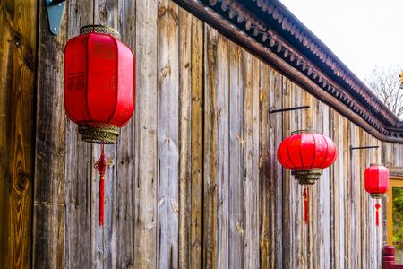 Chinese lanterns hanging on a wooden wall, Asian new year traditionの写真素材