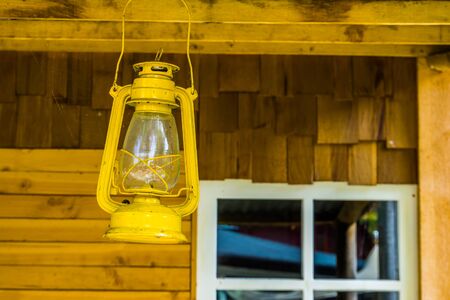 Yellow lantern hanging on the roof of a cottage, basic camp lightingの写真素材