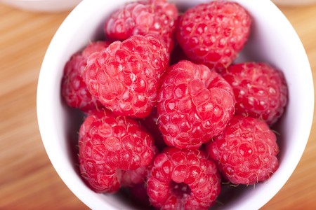 Raspberries in white bowl shot from directly above.の写真素材