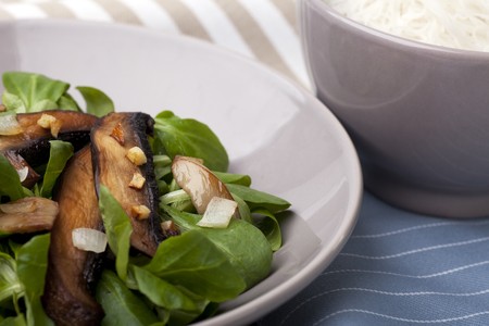 Warm mushroom salad on a bed of baby lettuce, served with cold soba noodles.の写真素材