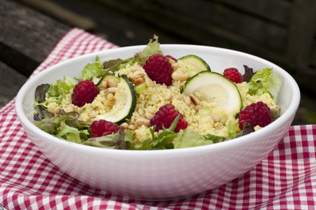 Couscous salad with zucchini and raspberries and pine nuts.の写真素材