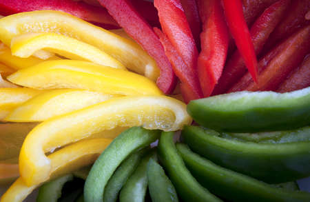 Closeup of red, yellow and green bell pepper slices.の写真素材