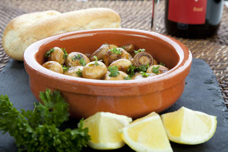Fresh marinated mushroom tapas with lemon and bread.の写真素材