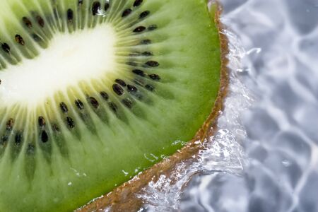 Kiwi under running water, with water running over sides.の写真素材