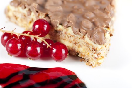 Close up of fresh red currants and slice of chocolate almond cakeの写真素材