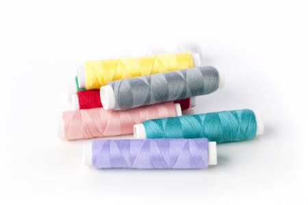 Spools of colorful thread isolated on white.