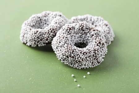 Donut shaped chocolates covered in white candy.の写真素材