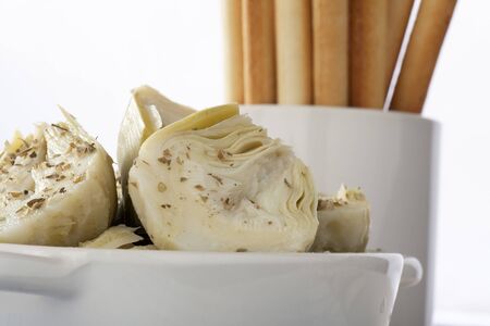 Healthy appetizer consisting of herbed artichoke hearts with bread sticks.の写真素材