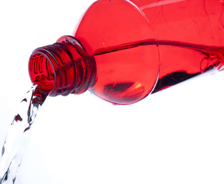 Red plastic bottle pouring water.の写真素材