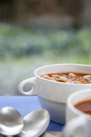 Hearty winter vegetable and white bean soup on a rainy afternoonの写真素材
