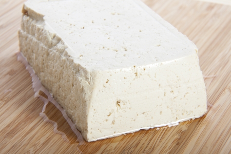 Block of fresh tofu on cutting block.の写真素材