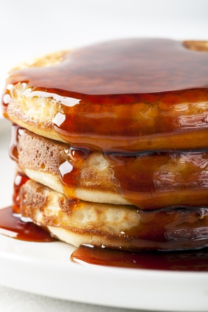 Close-up of stack of fresh pancakes covered in syrup.の写真素材