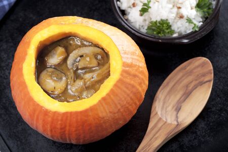 Creamy musrhoom and pumpkin soup in a pumpkin bowl.の写真素材
