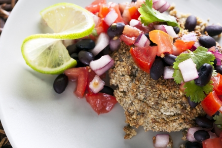 Black bean salsa on a veggie burger with lime garnishの写真素材