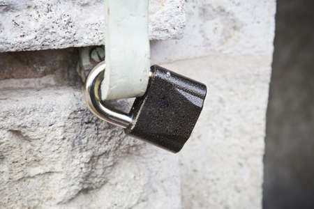 Locked padlock  on stone wall の写真素材