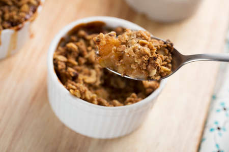 Spoon full of fresh apple crumble from single servingの写真素材