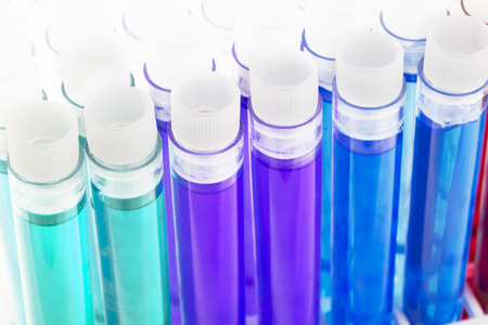 Colorful liquids, green, purple, blue, red and yellow, in test tubes with stoppers.